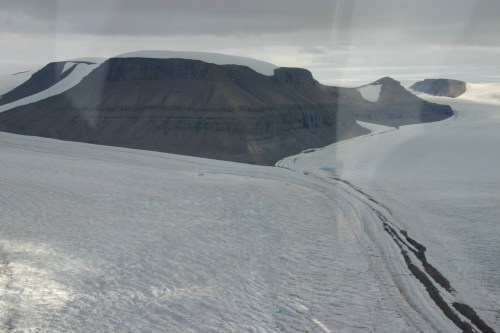The merging of Sigurd Berg and Hubert Glaciers which discharge into Petermann Gletscher on its eastern wall. The view is landward towards the north-east as the helicopter flies in from Petermann. [Credit: Barbara O'Connell, Canadian Coast Guard]  