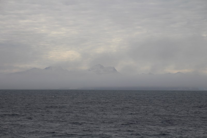 Coastal Greenland in the fog as we approach the entrance to Scoresby Sund on Aug. 20, 2018. [Photo by Dragonfly Leathrum]